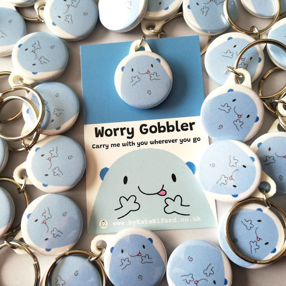 Lots of worry gobbler mini round keyrings. Blue cute blob character on a backing card with the words worry gobbler carry me with you wherever you go.