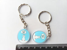 Load image into Gallery viewer, Mini oval recycled acrylic keyring. The design is a little penguin on a light blue background with a speech bubble saying you're the best. There are two keyrings in the photo next to a ruler to show the size
