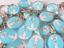 Load image into Gallery viewer, Mini oval recycled acrylic keyrings in a big pile. The design is a little penguin on a light blue background with a speech bubble saying you're the best.
