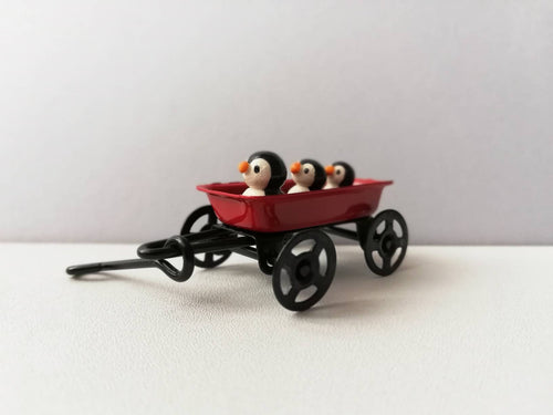 Penguins in a cart. Little pottery penguin in a mini red truck. Cute penguins
