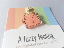 Load image into Gallery viewer, A fuzzy feeling. A little peachy orange happy, fuzzy looking character. It has a clip to be used as a charm or stitch marker
