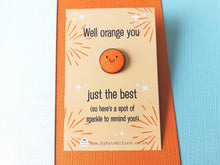 Load image into Gallery viewer, A mini round orange glittery pin with a smiley face. The wording on the card reads well orange you just the best, so here is a spot of sparkle to remind you!
