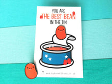 Load image into Gallery viewer, Baked bean enamel pin. The word on the card reads you are the best bean in the tin
