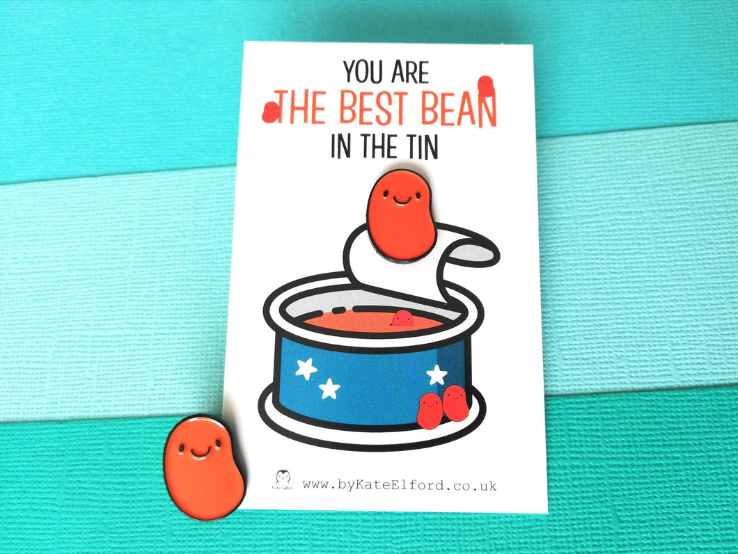 Baked bean enamel pin. The word on the card reads you are the best bean in the tin