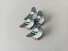 Load image into Gallery viewer, Four pigeon-shaped enamel pins. Each pin has a grey head, light blue body, and black and white wings. The chest features pink and green detailing, and the feet are pink.
