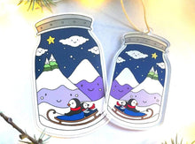 Load image into Gallery viewer, Penguins in a jar decoration. Cute winter charm ornament. Penguin and chick, penguin, sledge, mountains, star and snow, recycled acrylic
