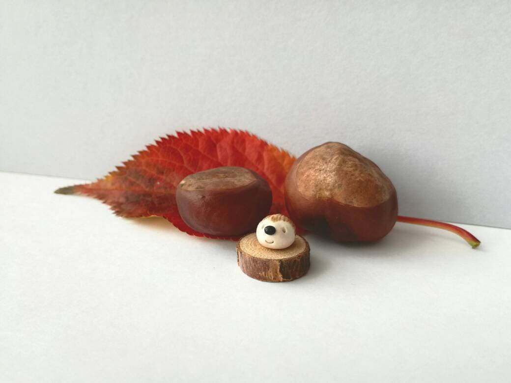 Miniature hedgehog ornament. Pottery hedgehog on wood base