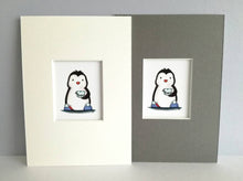 Load image into Gallery viewer, Cute black and white penguin, wearing blue pom pom slippers and holding tea, in a blue polka dot cup and saucer. Available in a coice of 7 x 5 inch grey or white mount
