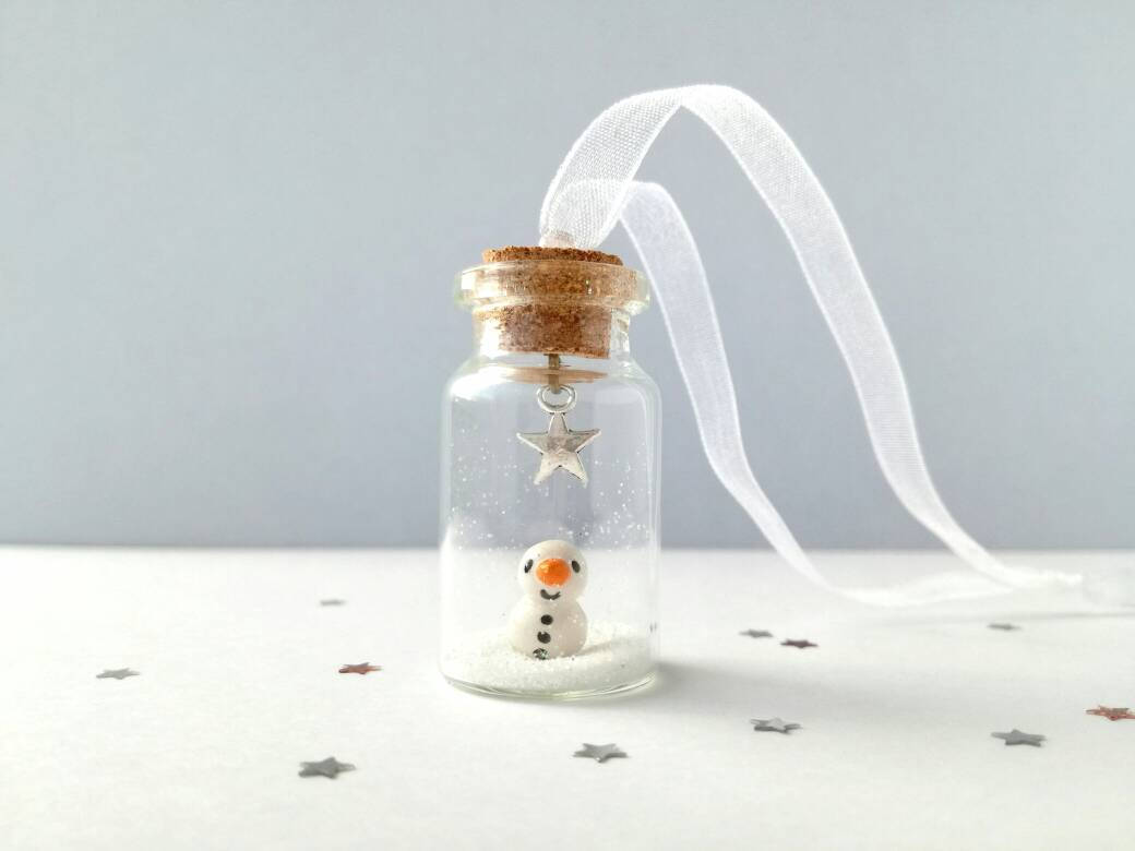 Miniature snowman decoration. Little pottery snowman in a glass bottle. Christmas mini ornament