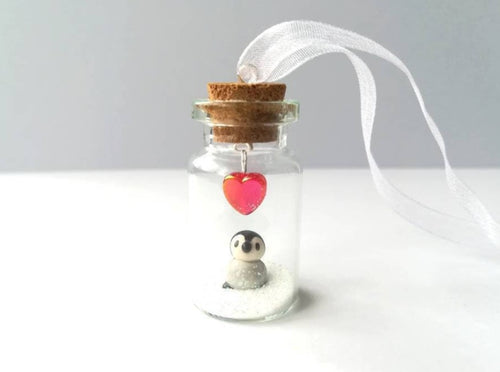 Miniature penguin chick gift. Little pottery penguin in a glass bottle. Red love heart mini penguin ornament