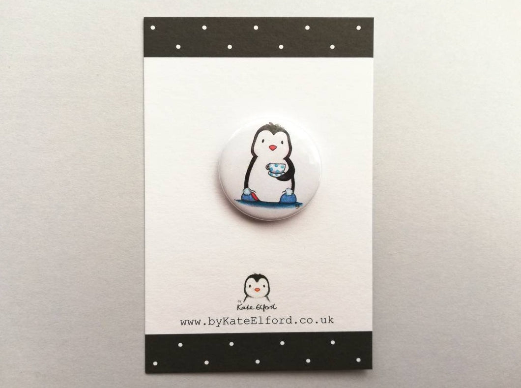 Mini button badge, the design is a penguin in blue slippers holding a cup of tea