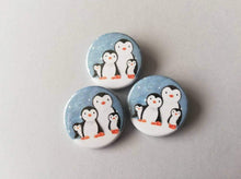Load image into Gallery viewer, Penguin button badge, snow scene, with family of penguins cuddling, great Christmas stocking filler
