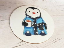 Load image into Gallery viewer, Penguin illustration coaster. Penguin is wearing a polka dot blue dressing gown, slippers and having a cup of tea
