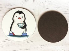 Load image into Gallery viewer, Back and front of a penguin coaster. A black and white penguin on a white background. Penguin is wearing blue slippers with pom poms on the toes, and is holding a polka dot cup and saucer
