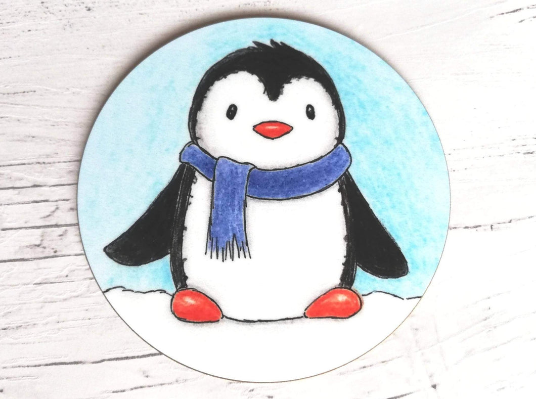 Coaster. Cute penguin in the snow wearing a blue scarf