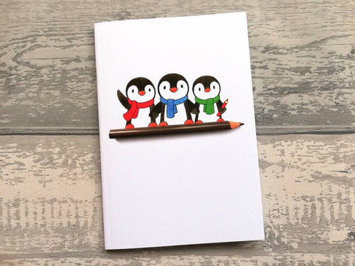 A6 notebook, cute penguins sat on a pencil. Small lined notepad