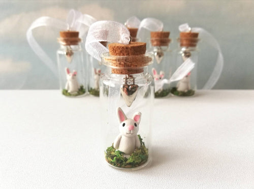 Miniature rabbit decoration. Little pottery white rabbit in a glass bottle. Mini bunny ornament and silver heart. Easter tree