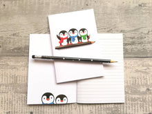 Load image into Gallery viewer, A6 notebook, cute penguins sat on a pencil. Small lined notepad
