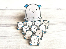 Load image into Gallery viewer, Enamel pins by Kate Elford, little white glitter monsters with a matching sticker

