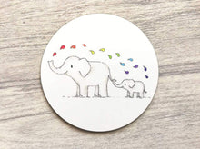 Load image into Gallery viewer, Elephant round coaster. Two elephants on a white background squirting rainbow colour drops of water from their trunk

