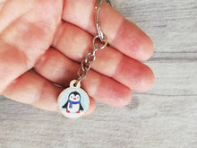 Load image into Gallery viewer, Little penguin keyring, cute mini tag, blue wooden key chain, penguin wearing a scarf in snow,ethically sourced wood, eco friendly charm
