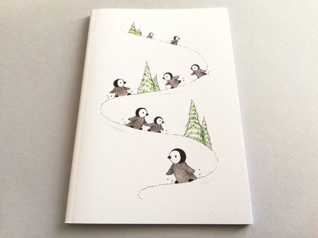 A6 notebook, penguins playing in the snow. Small lined notepad.