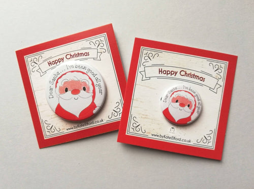 Two badges small and large both with a drawing of Father Christmas, it has the wording Dear Santa, I've been good all year. It is mounted on a backing card that says Happy Christmas