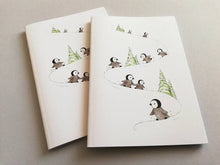 Load image into Gallery viewer, A6 notebook, penguins playing in the snow. Small lined notepad.

