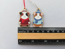 Load image into Gallery viewer, Guinea pig Christmas little decorations. Ethically sourced eco friendly. Choice of blue or red. Cute Christmas tree ornaments.

