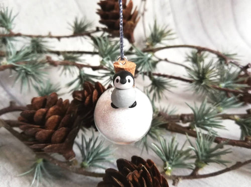Tiny penguin chick decoration. Miniature pottery penguin chick on a glass bauble. Very small Christmas mini penguin ornament